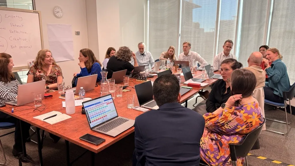 A large leadership group working through a session in a client boardroom