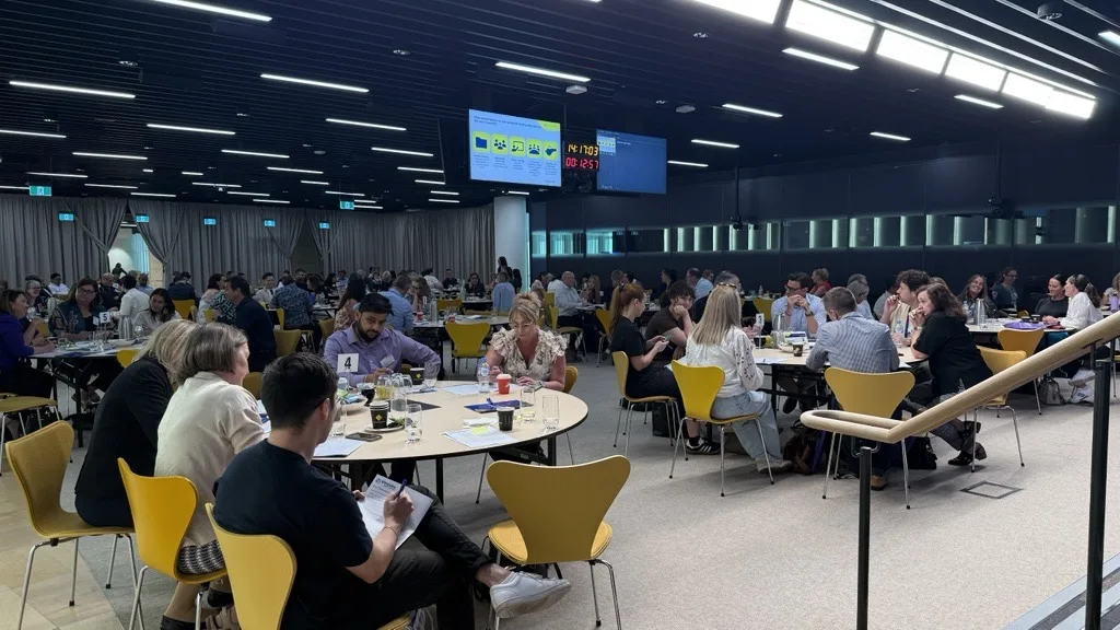 A large leadership group working through a session in a client boardroom
