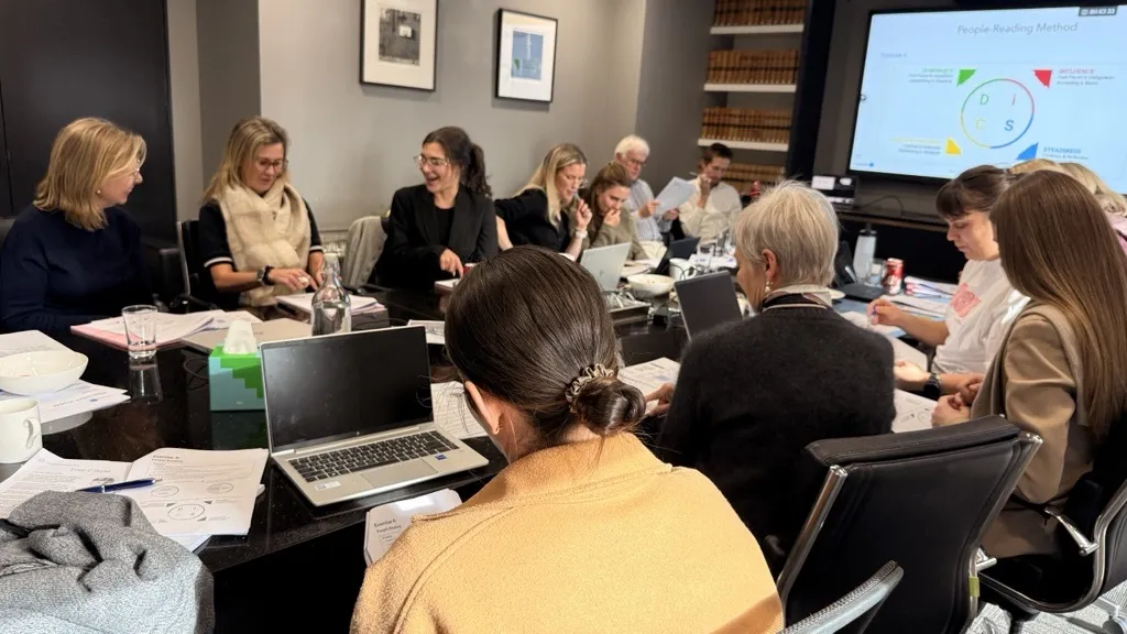 A leadership team working through a session around the boardroom table